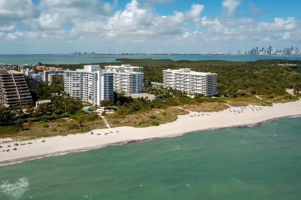 Florida, ABD 'deki hava aracı fotoshoot görüntüleri, ticari alan, lüks evler, binalar ve malikaneler, çevrede bol miktarda tropikal bitki örtüsü, mavi gökyüzü ve botlu su kanalı.