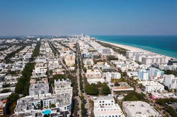 Florida, ABD 'deki hava aracı fotoshoot görüntüleri, ticari alan, lüks evler, binalar ve malikaneler, çevrede bol miktarda tropikal bitki örtüsü, mavi gökyüzü ve botlu su kanalı.