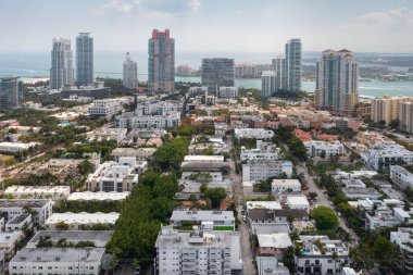 Florida, ABD 'deki hava aracı fotoshoot, ticari alan, lüks evler, binalar ve malikaneler, turkuaz suyu, mavi gökyüzü ve su kanalı etrafında bol miktarda tropikal bitki örtüsü.