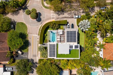 Florida, ABD 'deki hava aracı fotoshoot, ticari alan, lüks evler, binalar ve malikaneler, turkuaz suyu, mavi gökyüzü ve su kanalı etrafında bol miktarda tropikal bitki örtüsü.