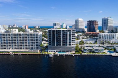 Florida, ABD 'deki hava aracı fotoshoot, ticari alan, lüks evler, binalar ve malikaneler, turkuaz suyu, mavi gökyüzü ve su kanalı etrafında bol miktarda tropikal bitki örtüsü.