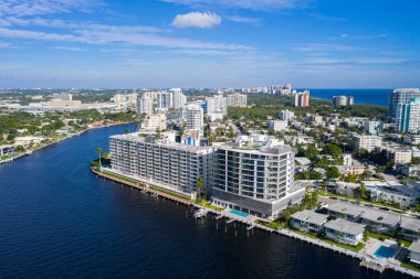 Florida, ABD 'deki hava aracı fotoshoot, ticari alan, lüks evler, binalar ve malikaneler, turkuaz suyu, mavi gökyüzü ve su kanalı etrafında bol miktarda tropikal bitki örtüsü.