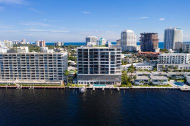 Florida, ABD 'deki hava aracı fotoshoot, ticari alan, lüks evler, binalar ve malikaneler, turkuaz suyu, mavi gökyüzü ve su kanalı etrafında bol miktarda tropikal bitki örtüsü.