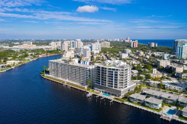 Florida, ABD 'deki hava aracı fotoshoot, ticari alan, lüks evler, binalar ve malikaneler, turkuaz suyu, mavi gökyüzü ve su kanalı etrafında bol miktarda tropikal bitki örtüsü.