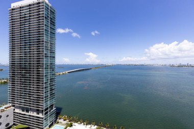 Florida, ABD 'deki hava aracı fotoshoot, ticari alan, lüks evler, binalar ve malikaneler, turkuaz suyu, mavi gökyüzü ve su kanalı etrafında bol miktarda tropikal bitki örtüsü.