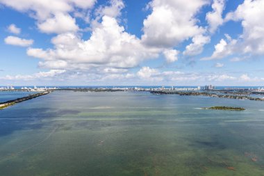 Florida, ABD 'deki hava aracı fotoshoot, ticari alan, lüks evler, binalar ve malikaneler, turkuaz suyu, mavi gökyüzü ve su kanalı etrafında bol miktarda tropikal bitki örtüsü.