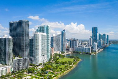 Florida, ABD 'deki hava aracı fotoshoot, ticari alan, lüks evler, binalar ve malikaneler, turkuaz suyu, mavi gökyüzü ve su kanalı etrafında bol miktarda tropikal bitki örtüsü.