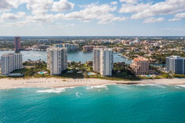 Florida, ABD 'deki hava aracı fotoshoot, ticari alan, lüks evler, binalar ve malikaneler, turkuaz suyu, mavi gökyüzü ve su kanalı etrafında bol miktarda tropikal bitki örtüsü.