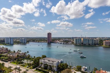 Florida, ABD 'deki hava aracı fotoshoot, ticari alan, lüks evler, binalar ve malikaneler, turkuaz suyu, mavi gökyüzü ve su kanalı etrafında bol miktarda tropikal bitki örtüsü.