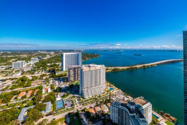 Florida, ABD 'deki hava aracı fotoshoot, ticari alan, lüks evler, binalar ve malikaneler, turkuaz suyu, mavi gökyüzü ve su kanalı etrafında bol miktarda tropikal bitki örtüsü.