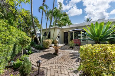 Bahçede yüzme havuzu, ağaçlar, sandalyeler. Mavi gökyüzü, yansıtan havuz ve okyanus, şehir mimarisi ve Florida manzaralı çevre, Usa.