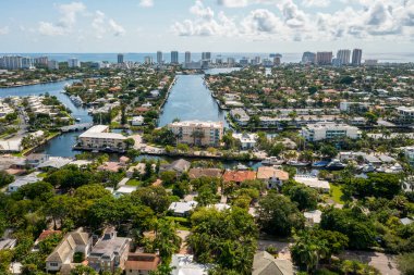 Florida, ABD 'deki hava aracı fotoshoot, ticari alan, lüks evler, binalar ve malikaneler, turkuaz suyu, mavi gökyüzü ve su kanalı etrafında bol miktarda tropikal bitki örtüsü.