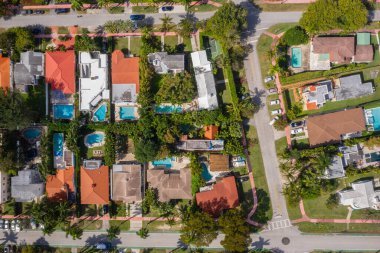 Florida, ABD 'deki hava aracı fotoshoot, ticari alan, lüks evler, binalar ve malikaneler, turkuaz suyu, mavi gökyüzü ve su kanalı etrafında bol miktarda tropikal bitki örtüsü.