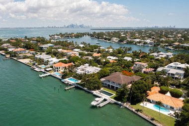 Florida, ABD 'deki hava aracı fotoshoot, ticari alan, lüks evler, binalar ve malikaneler, turkuaz suyu, mavi gökyüzü ve su kanalı etrafında bol miktarda tropikal bitki örtüsü.