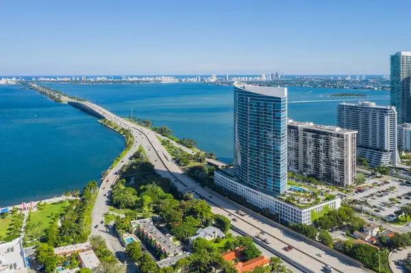 Florida, ABD 'deki hava aracı fotoshoot, ticari alan, lüks evler, binalar ve malikaneler, turkuaz suyu, mavi gökyüzü ve su kanalı etrafında bol miktarda tropikal bitki örtüsü.