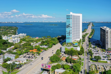 Florida, ABD 'deki hava aracı fotoshoot, ticari alan, lüks evler, binalar ve malikaneler, turkuaz suyu, mavi gökyüzü ve su kanalı etrafında bol miktarda tropikal bitki örtüsü.