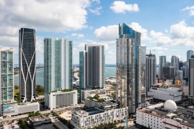 Florida, ABD 'deki hava aracı fotoshoot, ticari alan, lüks evler, binalar ve malikaneler, turkuaz suyu, mavi gökyüzü ve su kanalı etrafında bol miktarda tropikal bitki örtüsü.