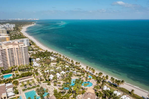 Florida, ABD 'deki hava aracı fotoshoot, ticari alan, lüks evler, binalar ve malikaneler, turkuaz suyu, mavi gökyüzü ve su kanalı etrafında bol miktarda tropikal bitki örtüsü.