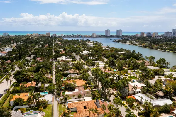 Florida, ABD 'deki hava aracı fotoshoot görüntüleri, ticari alan, lüks evler, binalar ve malikaneler, çevrede bol miktarda tropikal bitki örtüsü, mavi gökyüzü ve botlu su kanalı.