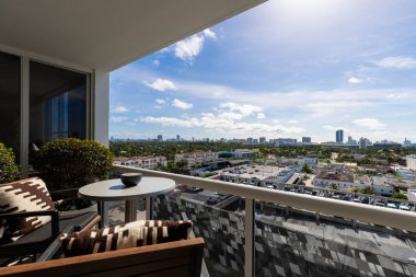 Masalı bir balkon ve şehre bakan sandalyeler.