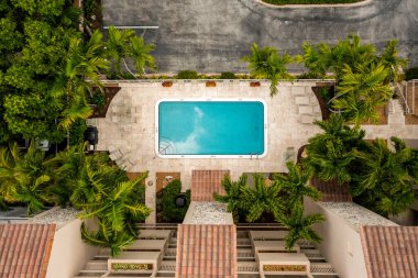 Palmiye ağaçları ve taş duvarlarla çevrili bir havuz.