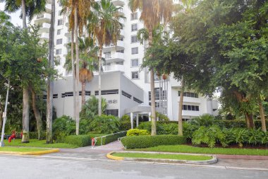 Bir sürü ağaç ve çalısı olan bir bina.