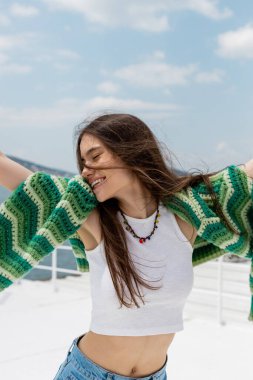 Happy young woman with knitted sweater standing on yacht during cruise in Turkey  clipart