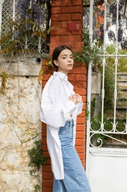 Pretty young woman in white shirt looking at camera on street in Turkey  clipart