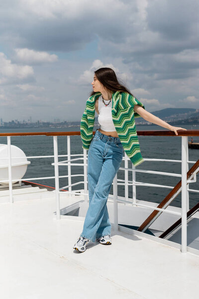 Side view of brunette woman looking away while standing on ferry boat in Turkey 