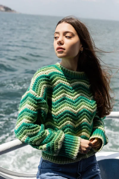 Jeune femme en pull tricoté debout sur un ferry avec la mer en arrière-plan en Turquie — Photo de stock