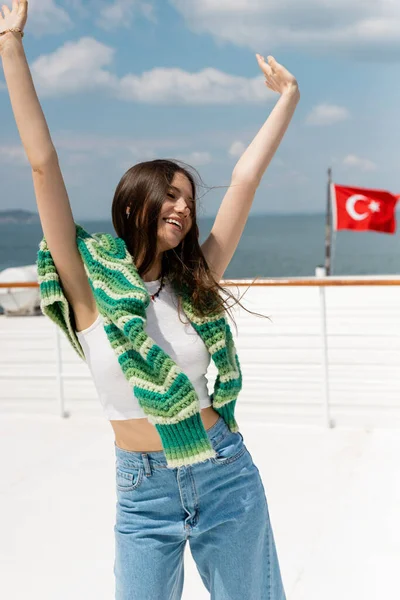 Carefree young tourist raising hands during cruise on yacht in Turkey — Stock Photo