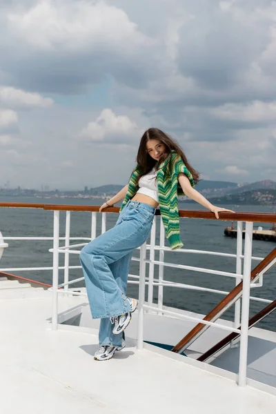 Carefree tourist standing near railing of ferry boat and looking at camera in Turkey — Stock Photo