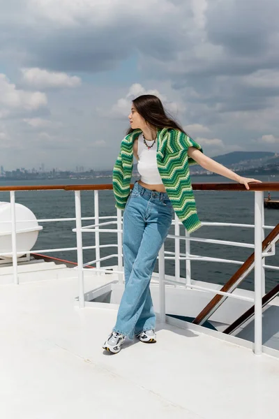 Vue latérale de la femme brune regardant loin tout en se tenant sur le ferry en Turquie — Photo de stock