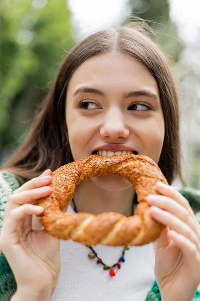 Young woman biting turkish simit bread outdoors in Istanbul — Stock Photo