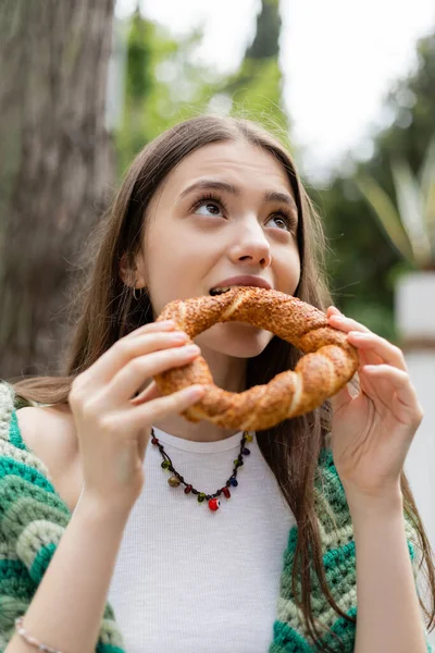 Brunette woman eating traditional turkish simit bread in Istanbul — Stock Photo