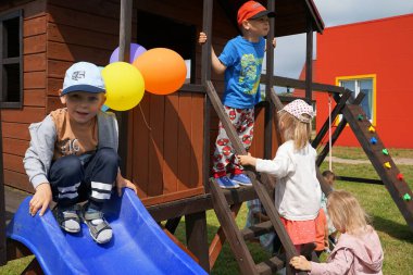 BATI POMERANYA, POLAND - CRCA HAZİRAN 2022: Tatil güneşinde, çocuklar yeni bir oyun parkının açılışının keyfini çıkarıyorlar
