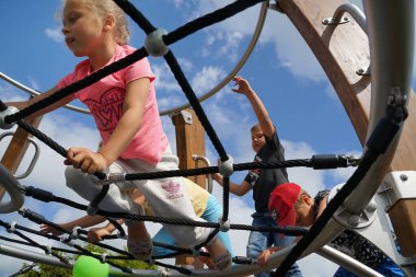 BATI POMERANYA, POLAND - CRCA HAZİRAN 2022: Tatil güneşinde, çocuklar yeni bir oyun parkının açılışının keyfini çıkarıyorlar