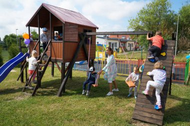 BATI POMERANYA, POLAND - CRCA HAZİRAN 2022: Tatil güneşinde, çocuklar yeni bir oyun parkının açılışının keyfini çıkarıyorlar