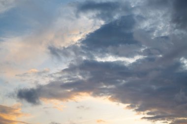 Gün batımında gökyüzü aydınlık ve kara bulutlarla.