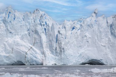 Glacier ice wall in Patagonia, ice texture and blue sky.