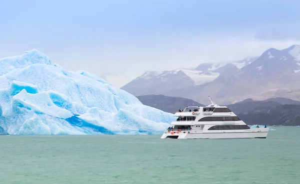 Boat passing iceberg in Patagonian waters.