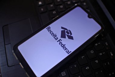 Rio de Janeiro, Brezilya. 02, 16, 2024. Klavyenin üstündeki cep telefonunun ekranındaki Brezilya Federal Gelirleri logosu.. 