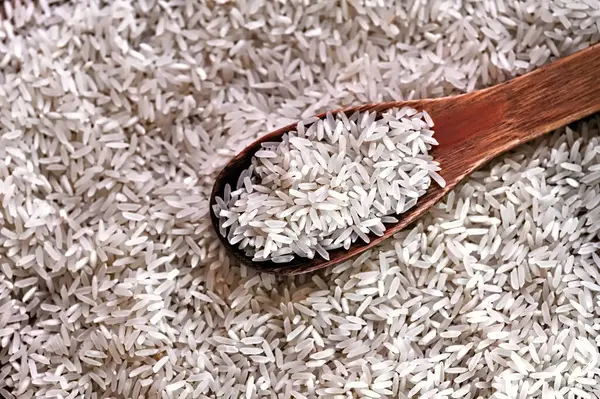 Masanın üzerindeki pirinç, tahta bir kaşıkla tutuluyor.