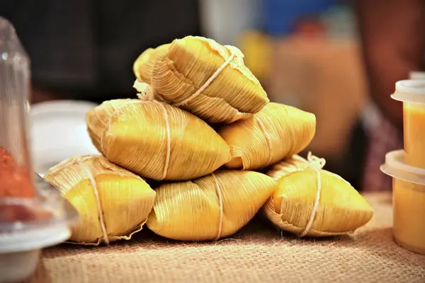 stock image Pamonha, corn-based Brazilian food, arranged on a rustic wooden table