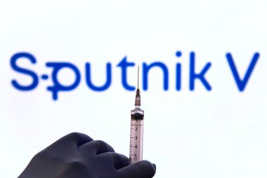 Sputnik aşısı. Şırıngayı tutan bir elin resmi ve arka planda Sputnik aşısının logosu. Covid-19. Rio de Janeiro, Brezilya - 08.28.2024