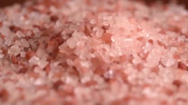 Tam ekran pembe himalaya tuzu. Pembe tuz taşları yakın planda. Pembe Himalaya nadir bulunan tuz kristali örtülü arka plan. Himalaya tuzunun sert kristalleri ahşap bir yüzey üzerinde
