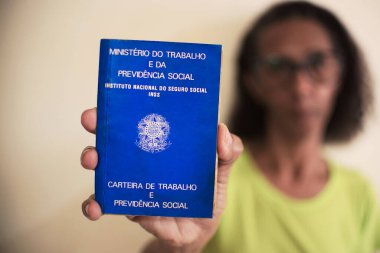 Rio de Janeiro, Brezilya - 14 / 11 / 2024: İş kartı tutan bir siyahın eli. Önerilen Brezilya Anayasası (PEC) sadece bir günlük izin ile 6x1 çalışma programını kaldırmayı ve 36 saatlik maksimum çalışma haftasını uygulamayı hedefliyor.