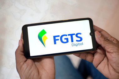 El ele tutuşan cep telefonu FGTS Dijital Uygulamasına bağlandı. İş hukuku kavramı, Brezilyalı işçilere destek ve istihdam. Hükümet, işten çıkarılma. Rio de Janeiro, Brezilya - 02.20.2025