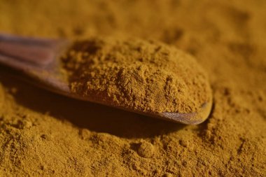 Tahta kaşıkta zerdeçal tozu. Tıbbi bitki ve süper yiyecek olarak kabul edilir..