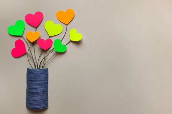 Bouquet of multi colored hearts in blue vase on light background with space for text. Flat lay. oncept of fun, happiness, freedom of feelings, pride lgbt. Copy space. lesbian community